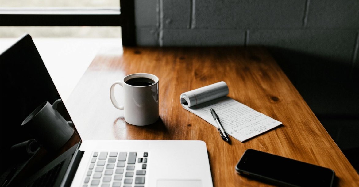 Bürotisch mit Kaffee und Notizblock