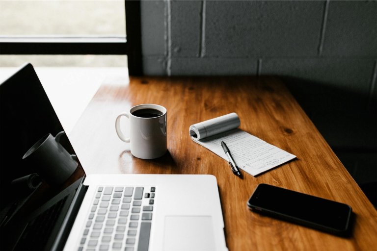Bürotisch mit Kaffee und Notizblock
